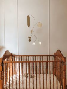 brass baby mobile, hanging mobile, cute baby in a cot, baby laughing at a mobile, handmade brass mobile, modern nursery ideas, nursery design