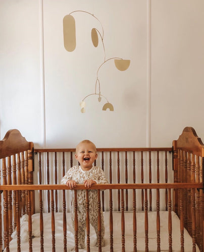 brass baby mobile, hanging mobile, cute baby in a cot, baby laughing at a mobile, handmade brass mobile, modern nursery ideas, nursery design